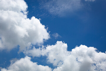Blue sky with soft white clouds in close-up view, creating a calm and refreshing natural background