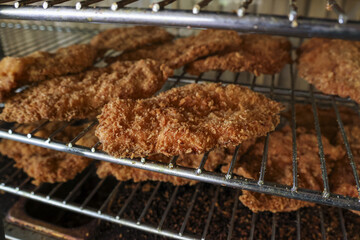 Satisfying meal of crispy golden brown fried chicken breast cutlets cooking on rack. This delicious homemade dinner popular comfort food recipe enjoyed by many