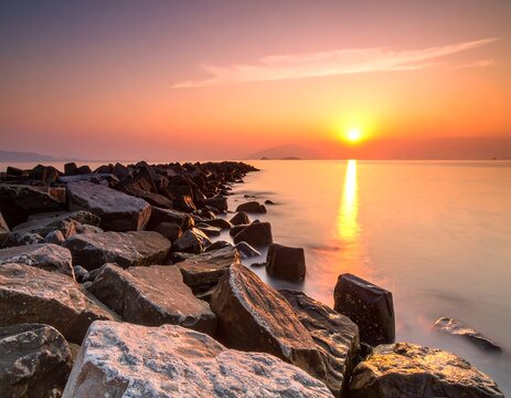 Rocky breakwater at a vibrant, calm sunrise - Powered by Adobe