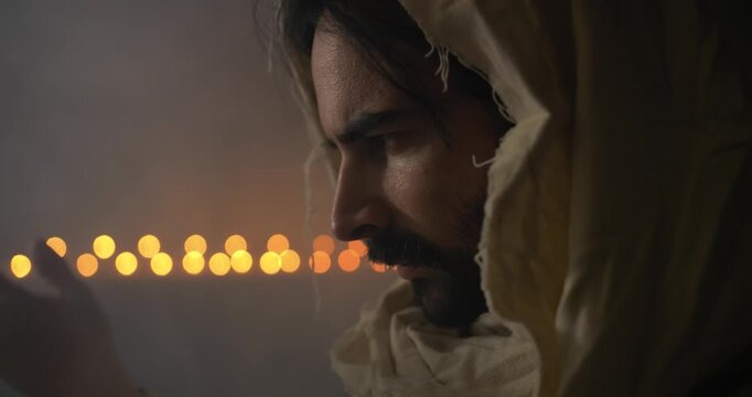 Closeup of religious man with beard praying in ambient light.