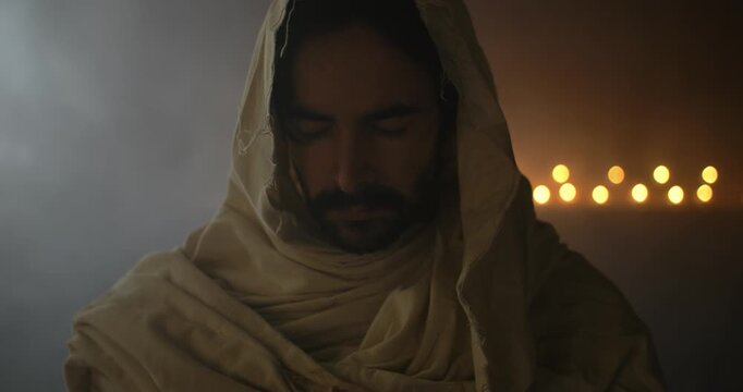 Closeup of Jesus Christ with Closed Eyes Praying in Ambient Light for Christianity stock footage.