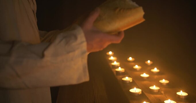 Jesus Christ holding bread for Passover, communion, sacraments, last supper over candlelight for Christianity stock footage.