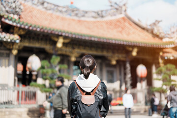 woman traveler visiting in Taiwan, female Tourist sightseeing at Longshan Temple, Chinese folk religious temple in Wanhua District, Taipei City. landmark and popular. Travel and Vacation concept