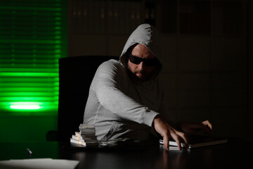 A masked thief steals money from an office during a dark night robbery. A hooded bandit sneaks into...