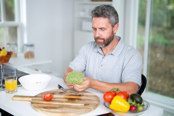 Healthy nutrition mature man. Aged man with healthy products at kitchen. Handsome Senior Man Eating Tasty Meal In Kitchen At Home. Elderly Man at Table Enjoying Delicious Food. Morning breakfast.