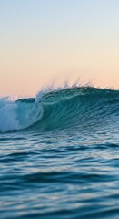 Powerful ocean wave breaking with crashing white foam. Blue water, orange and blue sky at sunrise or sunset. Nature power concept for design banner, poster, wallpaper or presentation.
