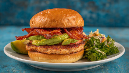 Gourmet chicken burger with avocado and bacon tomato