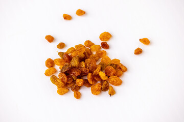 Close-up of many seedless raisins scattered on a white background. Natural sweet snack food made from dried grapes, great for a healthy diet.