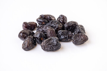 Delicious, healthy Ajwa dates isolated on a white background. Fresh, premium quality Ramadan fruit (Phoenix dactylifera) from Saudi Arabia. Sweet, nutritious, and high-fiber snack.