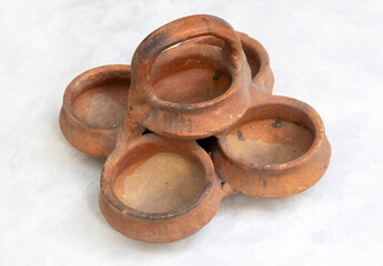 Group of five rustic, handmade clay pots clustered together. Traditional earthenware or terracotta pottery items with a natural, ethnic aesthetic for decor or crafts.