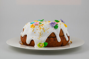 Decorated cake with icing and flowers on a white platter