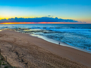 Obraz premium Sunrise at the beach with low cloud bank