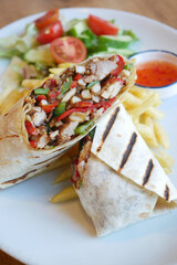 Delicious chicken burrito with fresh salad and fries