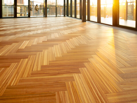 Warm wooden parquet floor with sunlight streaming through windows