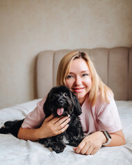 Woman relax on couch with puppy, happy and content at home with pet