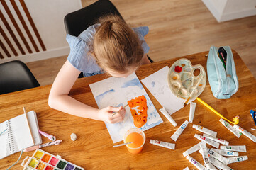 Cute little girl paints with paints