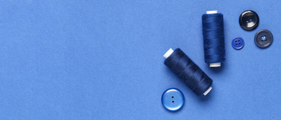 Fototapeta premium Threads and buttons on blue background with space for text, top view