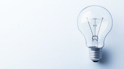 Clear light bulb with exposed filament on a plain white background, showcasing simple yet elegant design