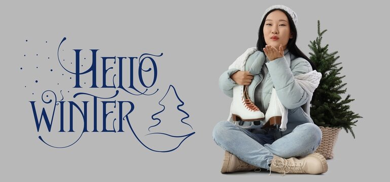 Happy Asian woman with ice skates and Christmas tree blowing kiss on grey background. Hello winter - Powered by Adobe
