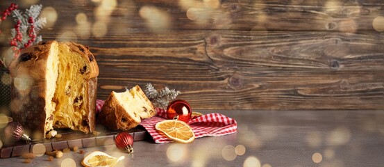 Cut Panettone and Christmas decor on wooden background with space for text