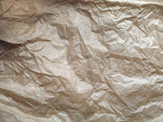 Vintage background from heavily crumpled paper, which is used as a wrapper. The texture of cardboard made from recycled materials.