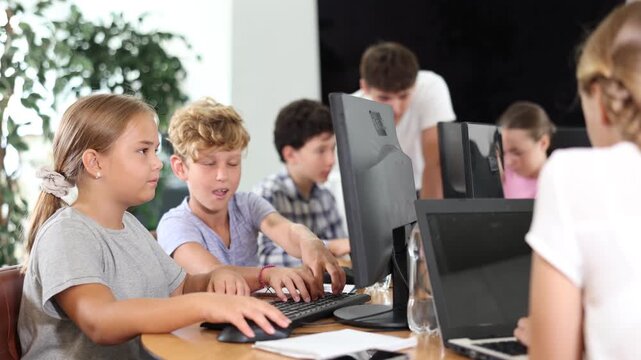 Computer science lesson in a school computer class - a girl and a boy solve problems on the computer together. High quality 4k footage
