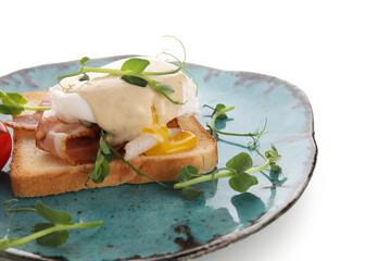 Plate of delicious egg Benedict with bacon and micro green on white background, closeup