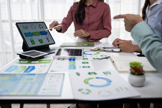 Collaborative strategy meeting on sustainable practices office workspace presentation materials professional environment close-up view teamwork insights