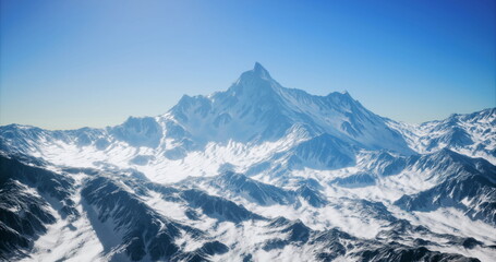 Fototapeta premium A breathtaking snow capped peak towers above rugged terrain under a brilliant blue sky. Surrounded by valleys and ridges, this stunning vista evokes a sense of wonder and tranquility.