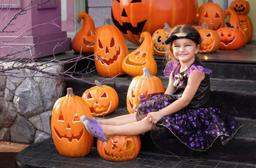 Girl in costume sitting on porch with halloween decorations