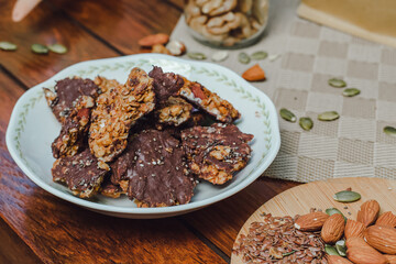 Homemade chocolate granola with almonds, pumpkin seeds, and chia seeds served in a white plate
