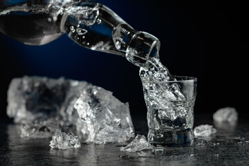 Crystal clear vodka or gin being poured into a glass.