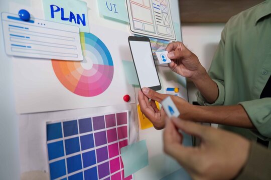 Teamwork in UI Design. Hands placing elements on a planning board. - Powered by Adobe