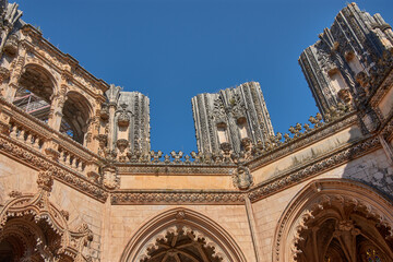 Architectural detail of the unfinished chapel in Batalha with Gothic tracery and pinnacles on a...