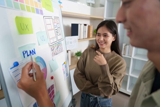 Engaging UI Design Session. Young woman smiling during a planning discussion.