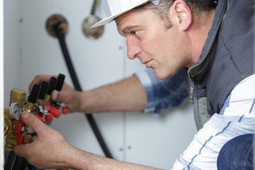 caucasian plumbing technician checking valves