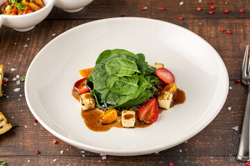 Fresh green salad with lime, strawberries, and nuts served