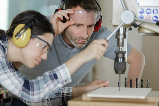 female apprentice learning to drill