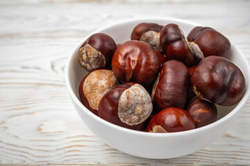 Group of chestnuts without their shells in the bowl on a white background