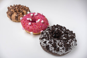 Three glazed bagels isolated on a white background. The donuts with sprinkles.