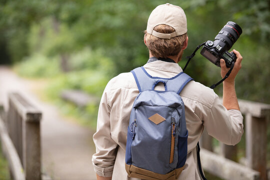 man photographer holding camera in forest