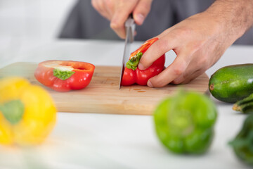 hands of chef cook cutting vegetables on wooden table