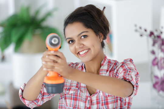 woman drilling wall in new house