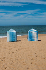 Traditional Blue and White Beach Cabins on Sandy Shore