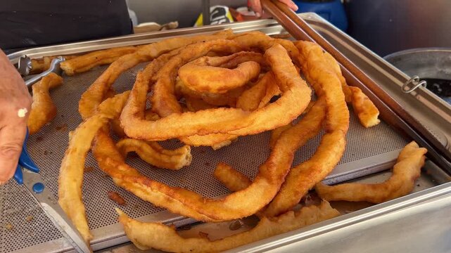 Woman cutting with scissors hot churros desert freshly made