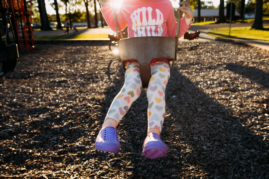 Young girl in child swing at park playground