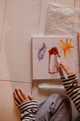 Children painting with watercolors on small canvases
