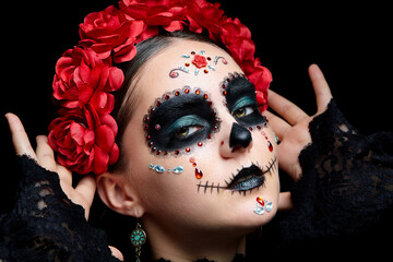 Halloween beauty portrait of woman. Beautiful female face adorned with Santa Muerte makeup.