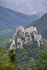 Scenic vertical mountain landscape overlooking ancient medieval Puilaurens cathar castle ruin in Pyrenees range, Lapradelle-Puilaurens, Aude, France