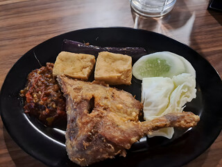 Fried Chicken Leg with Tofu Vegetables and Side Dishes on Black Plate